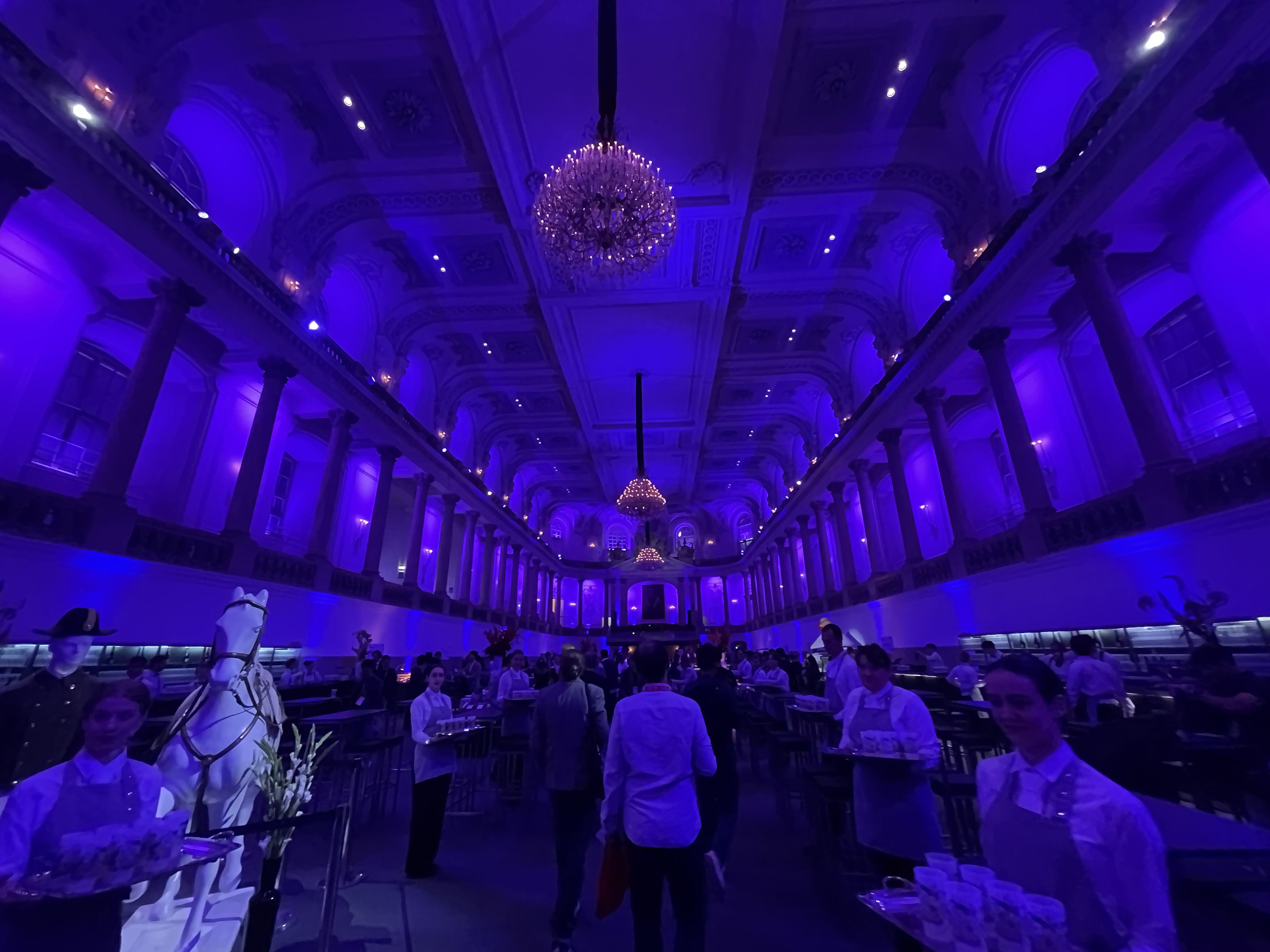 ICRA attendees gathering under blue light and chandeliers at Imperial Night